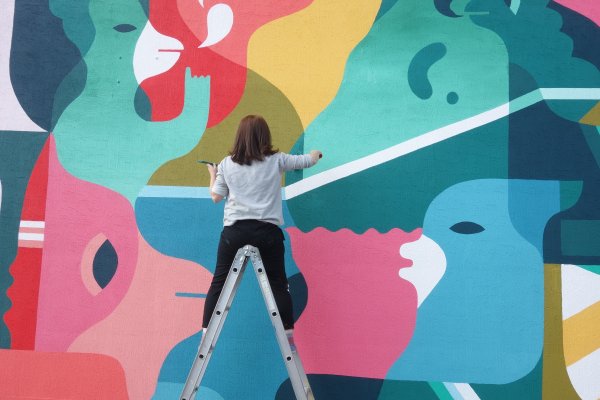 The artist in action for Ayajin primary school in 2014. It’s easy to see why children might like the bright colors and cartoon shapes. Photo: Sixcoin.